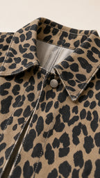 Close-up of leopard print textured woven fabric, collar, and snap zip closure