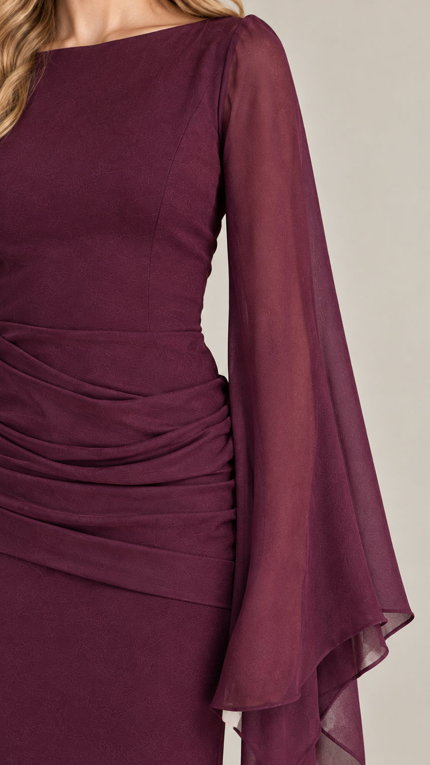 Close-up detail of sheer draped sleeve and ruched waist gathering on burgundy gown