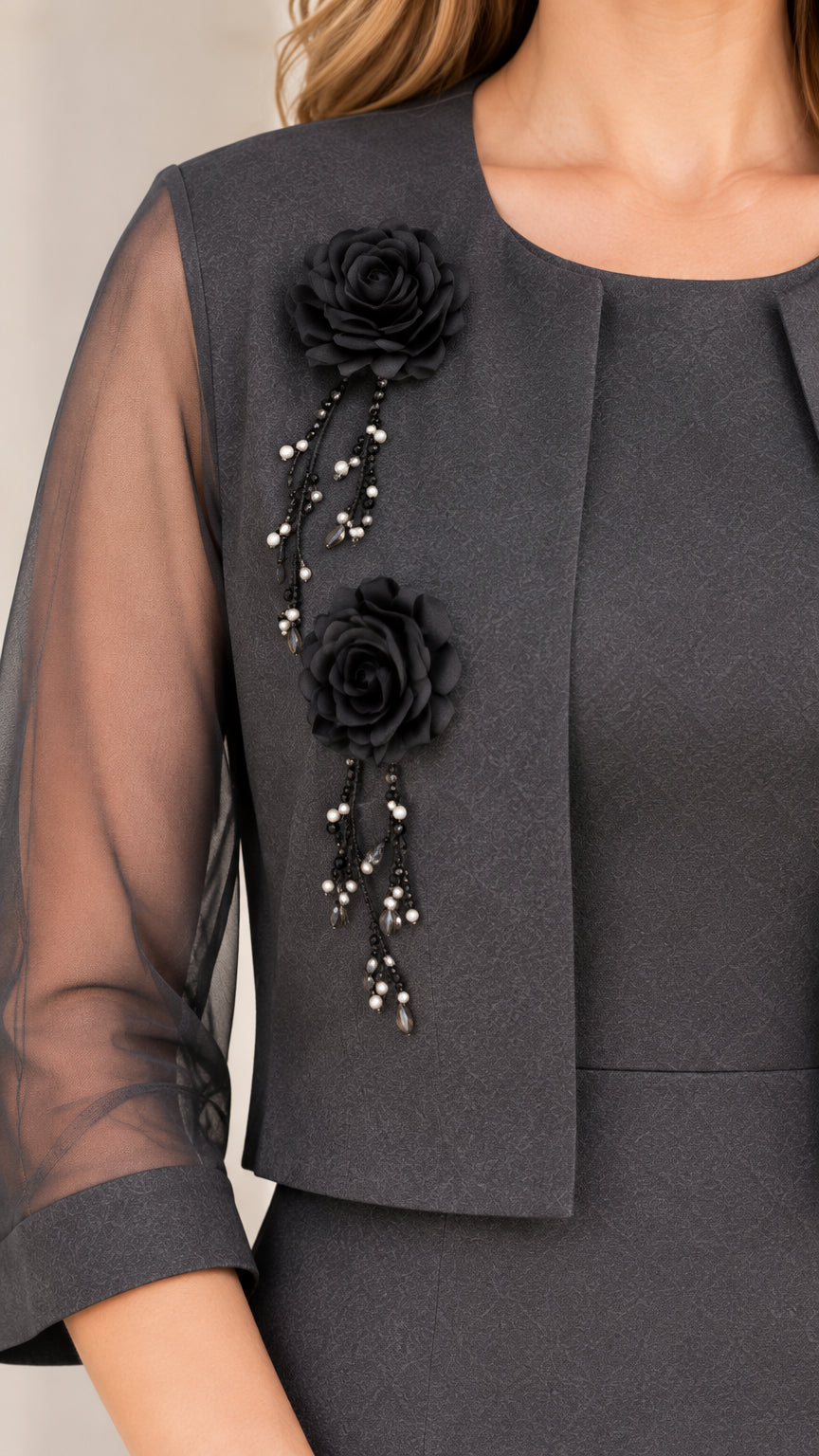 Close-up detail of 3D floral rosettes and beaded accents on charcoal jacket