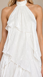 Close-up detail of the gathered halter collar and textured tiered ruffles on the white dress