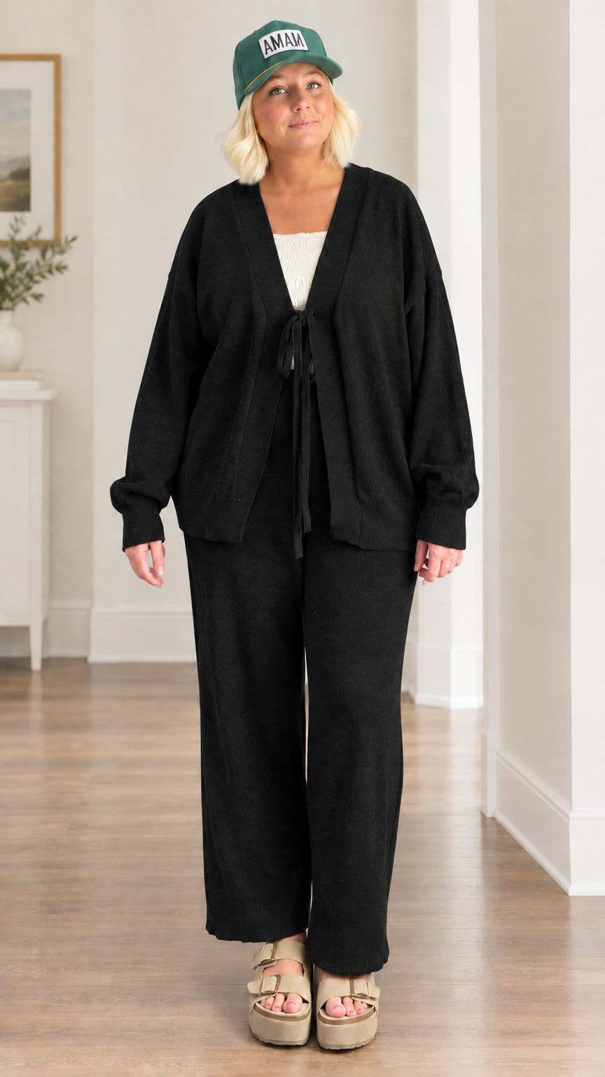 Woman wearing black 2-piece front-tie cardigan and matching wide-leg trousers