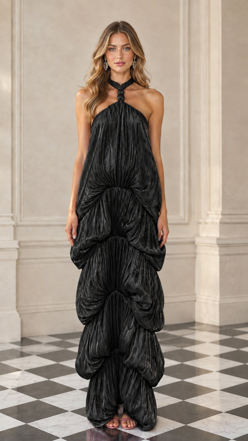 Front full-length view of model wearing black pleated shimmer halter tiered maxi dress