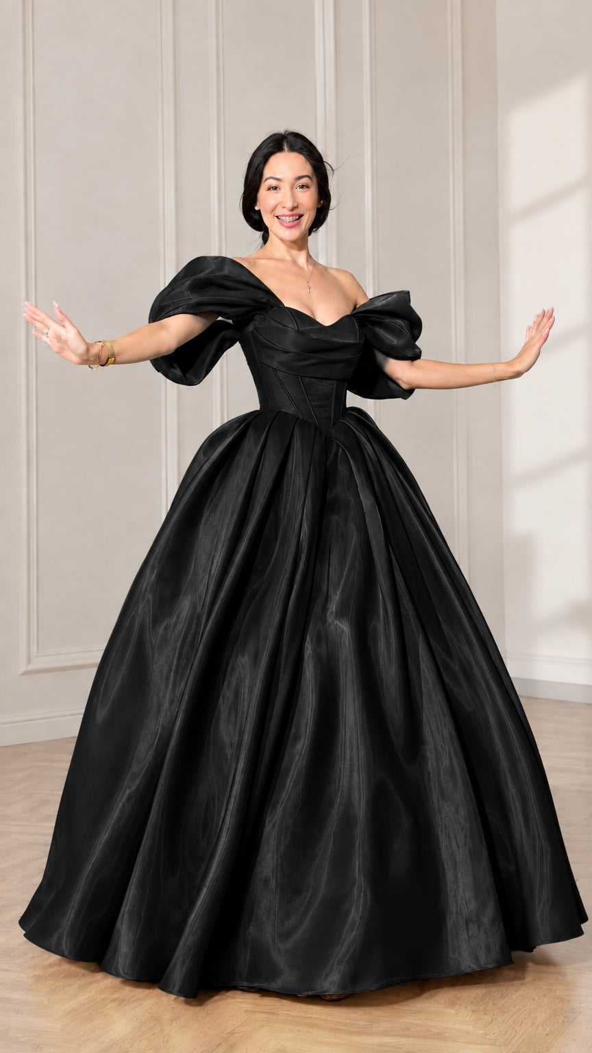 Front view of model wearing a black off-shoulder puff sleeve corset ball gown