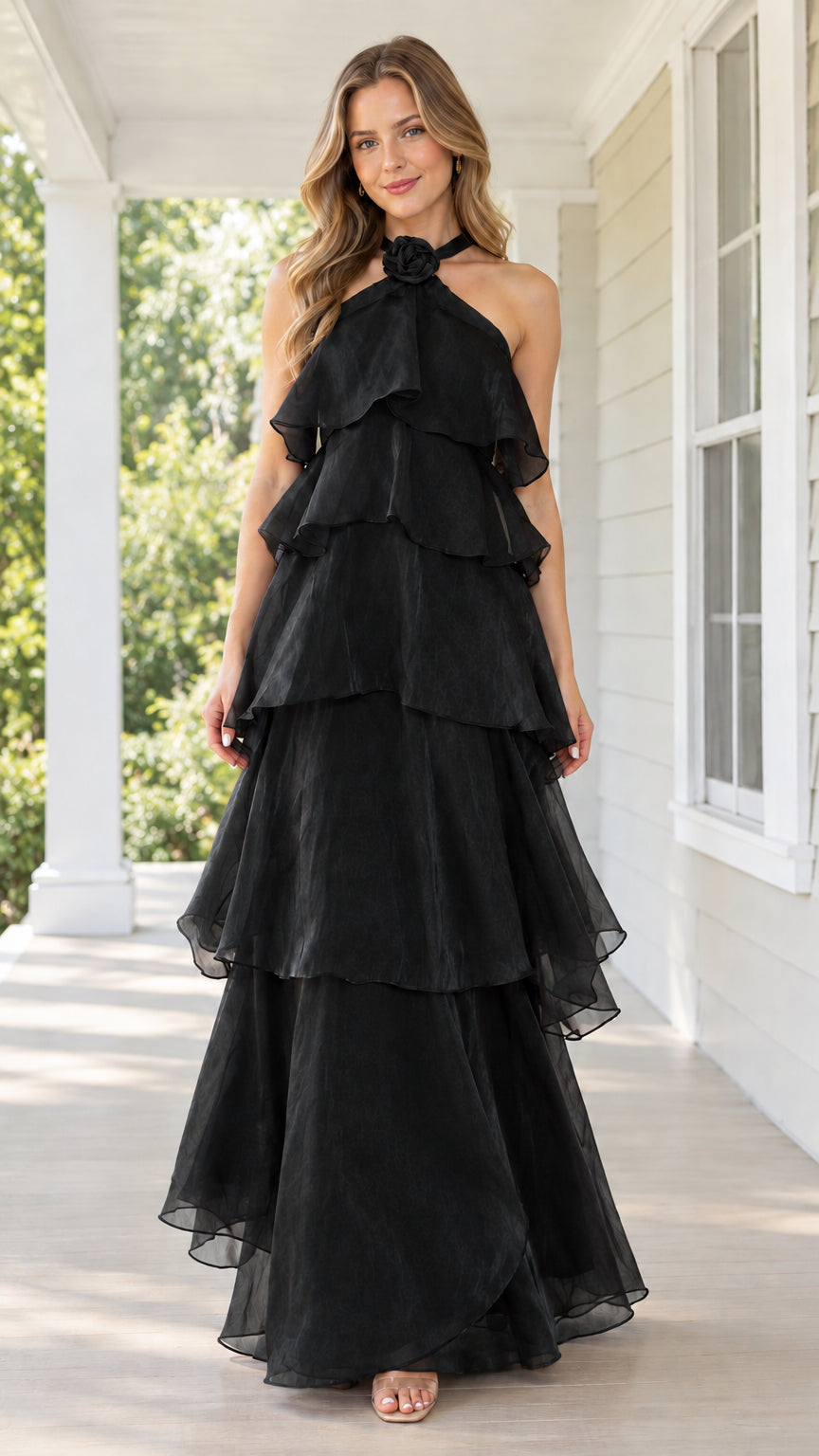 Front view of black tiered halter maxi dress with floral neck accent
