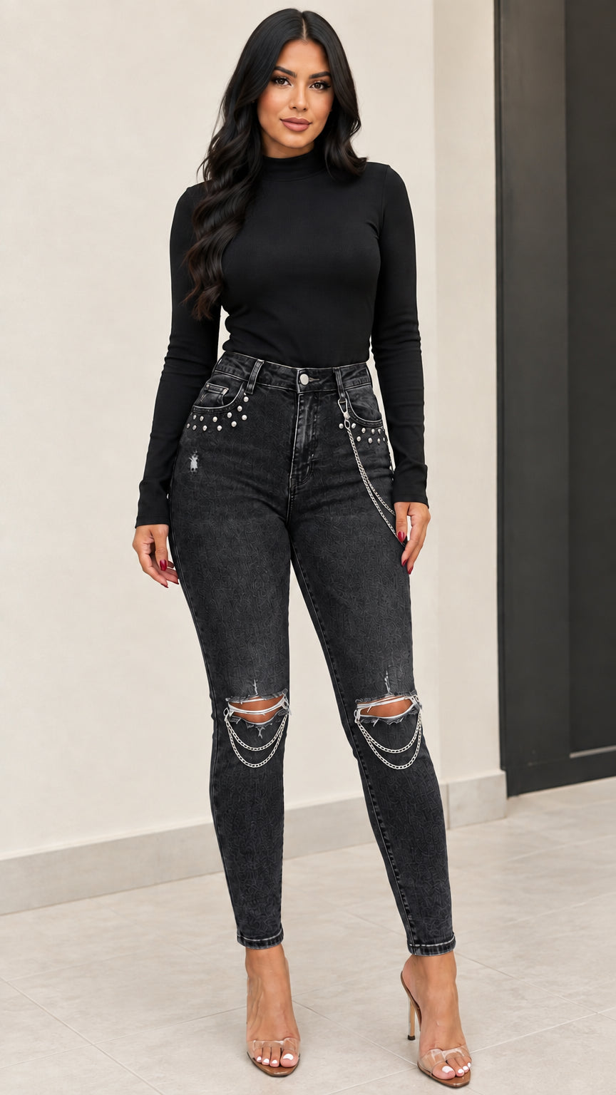 Front view of woman wearing washed black distressed skinny jeans with draped knee chains