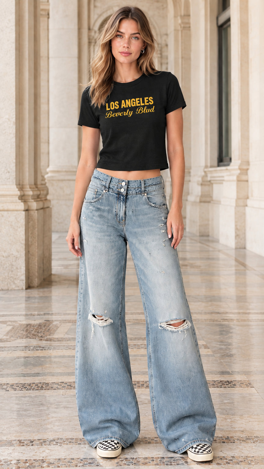 Model wearing black graphic baby tee paired with light-wash ripped wide-leg jeans