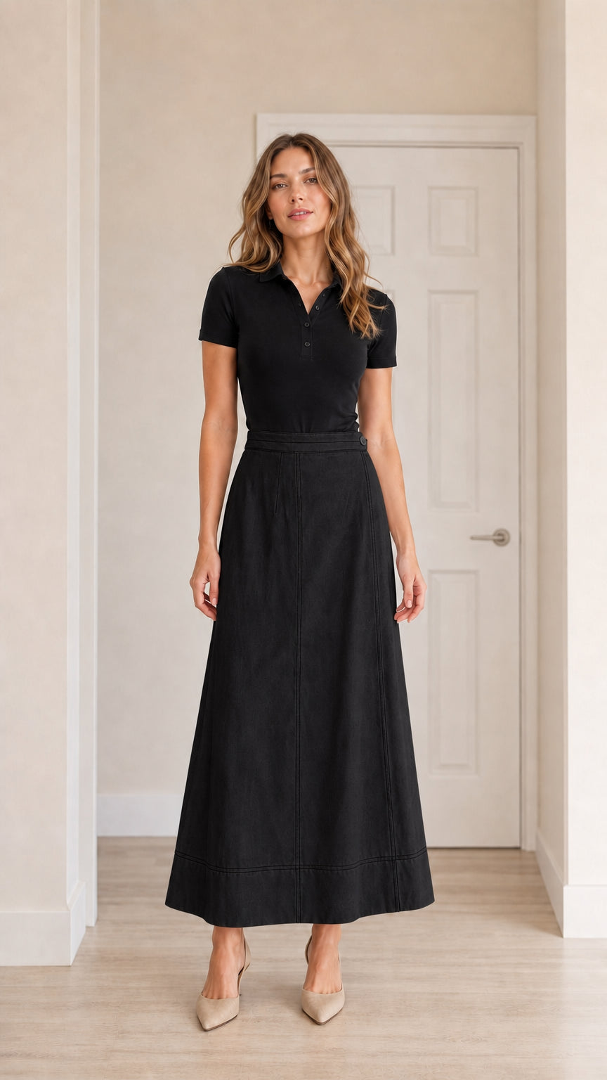 Front view of model wearing black high-waisted A-line maxi skirt