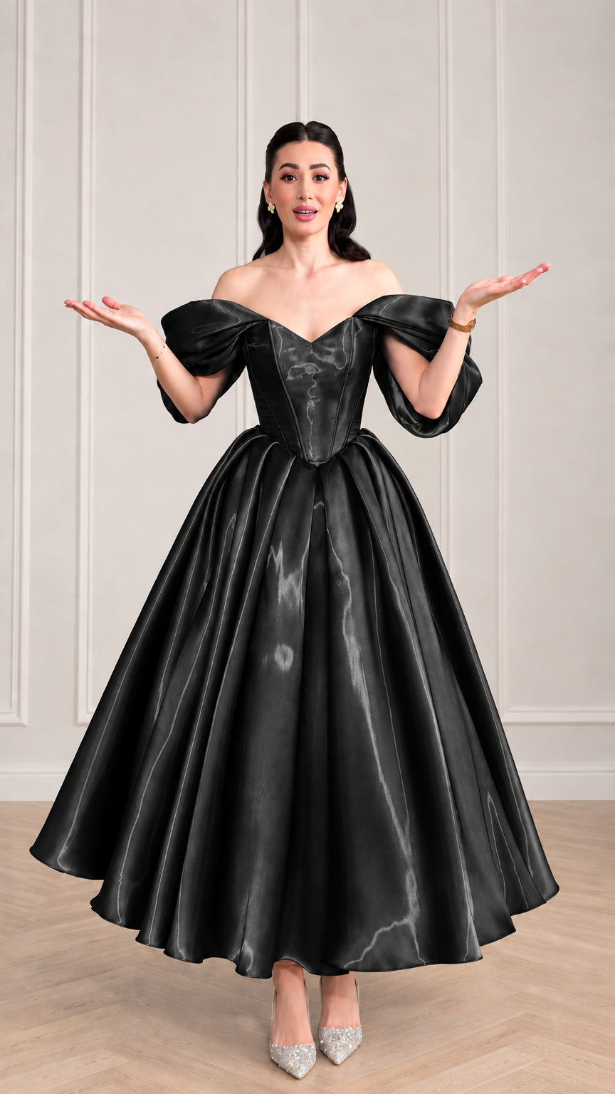 Woman wearing black off-the-shoulder corset satin evening gown with voluminous flared skirt