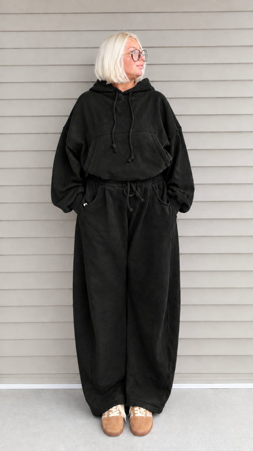 Front view of woman wearing black oversized hoodie and wide-leg sweatpants lounge set