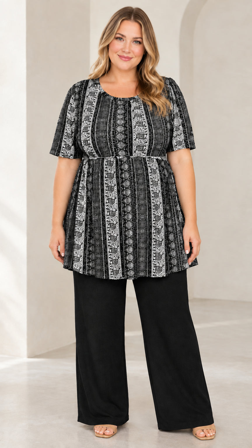 Model wearing Black and white vintage print empire waist tunic with solid black wide leg pants