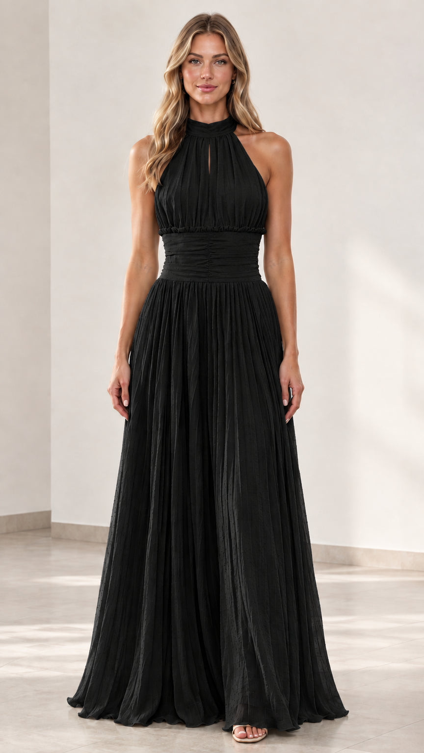 Front view of woman wearing black halter-neck pleated maxi dress