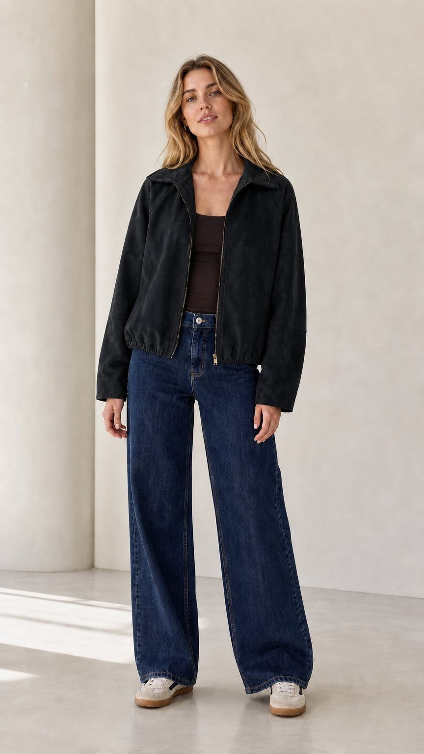 Front view of the black cropped faux suede jacket styled with a dark tank and wide-leg jeans