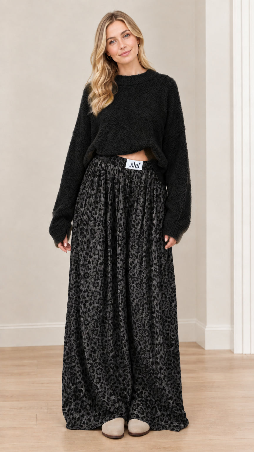 Model wearing black textured knit sweater paired with charcoal black leopard wide-leg pants