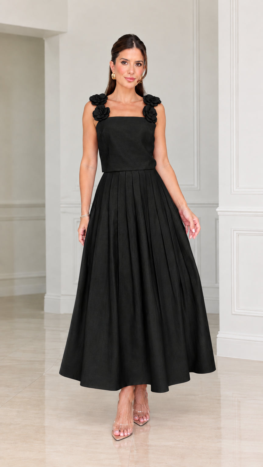 Front view of woman wearing black floral applique pleated midi dress