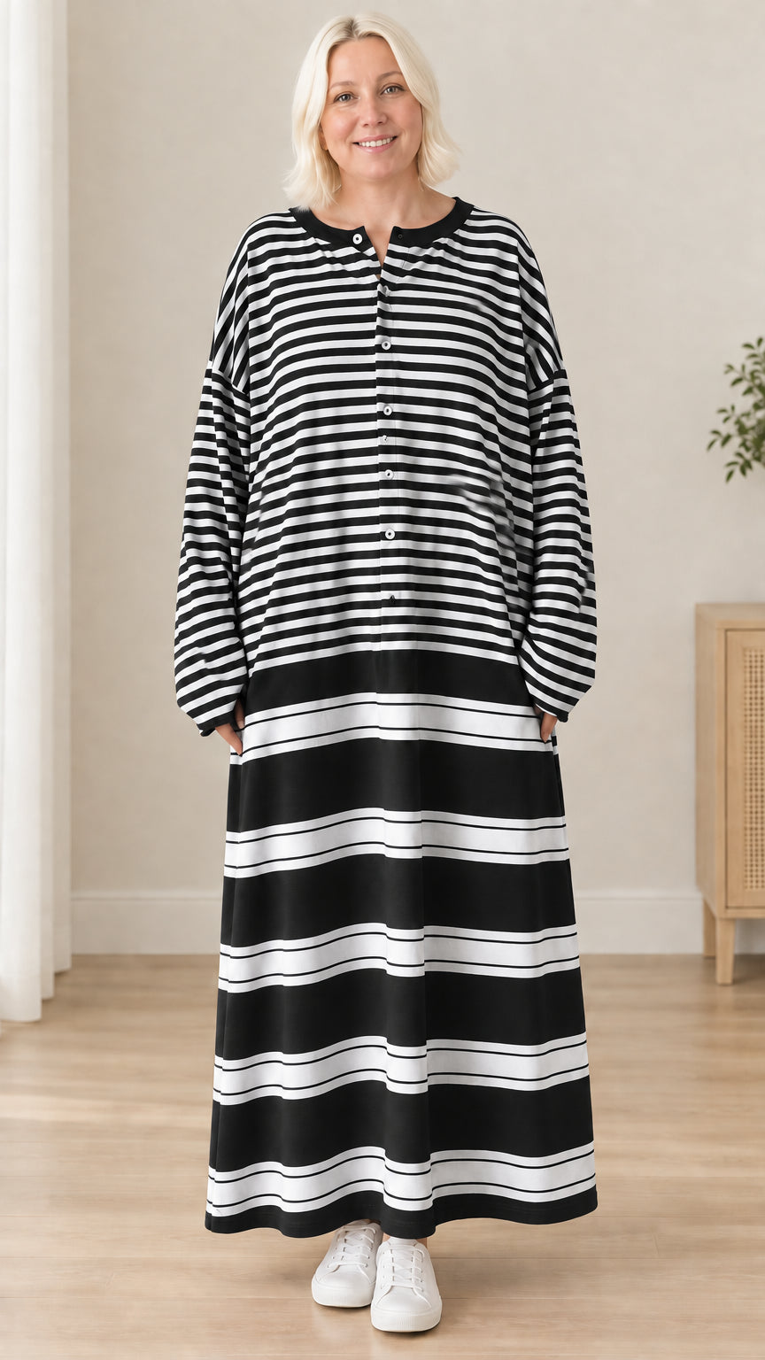 Front view of woman wearing black and white striped long sleeve maxi dress