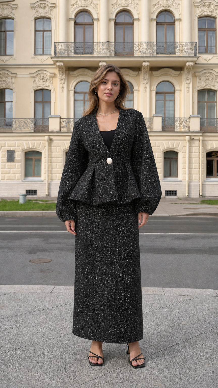 Front view of model wearing black tweed peplum jacket and maxi skirt set