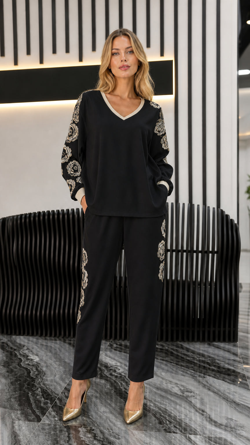 Front view of woman wearing black embroidered two-piece top and pants set