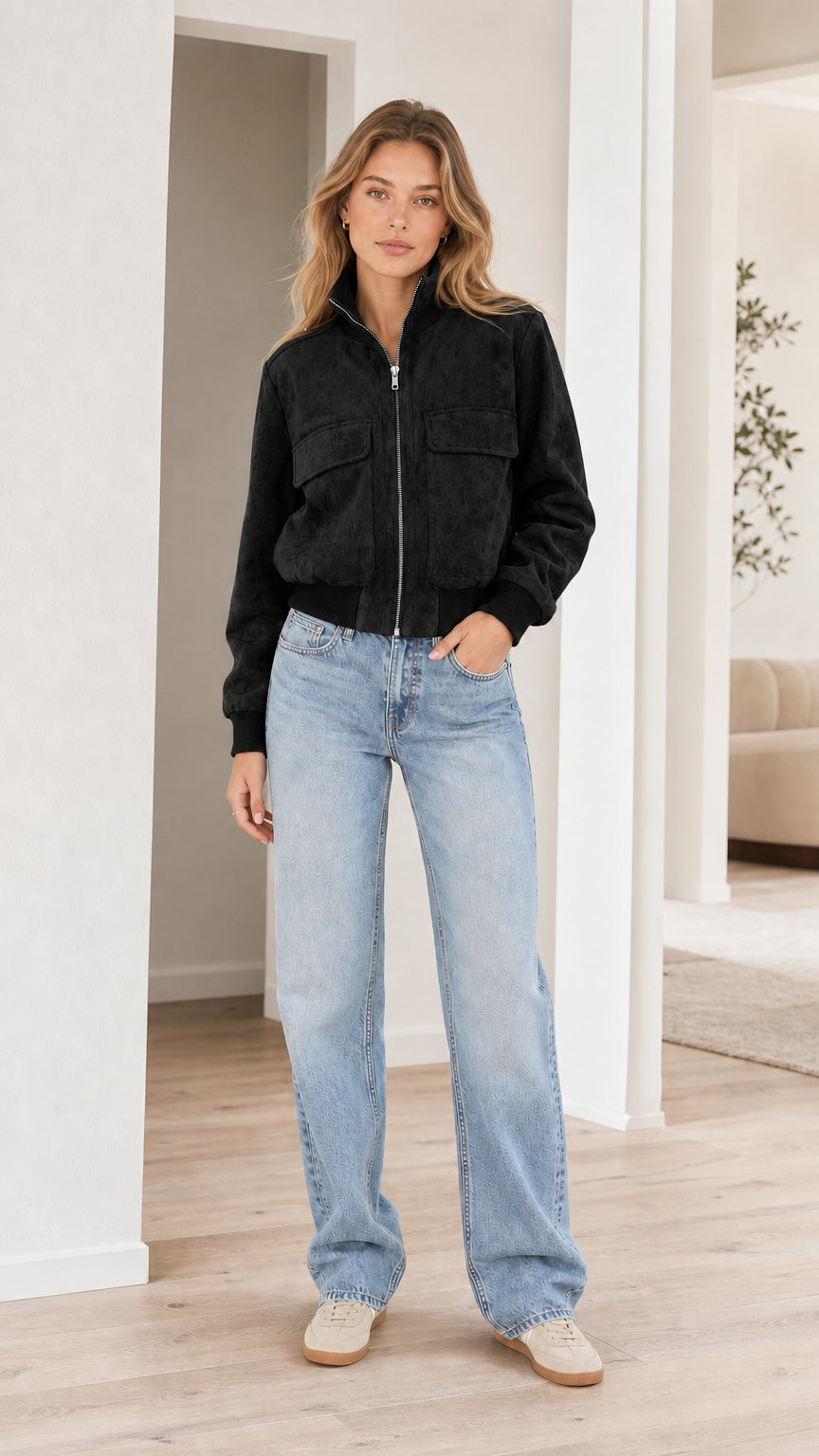 Model wearing black faux suede zip-up bomber jacket with straight-leg jeans