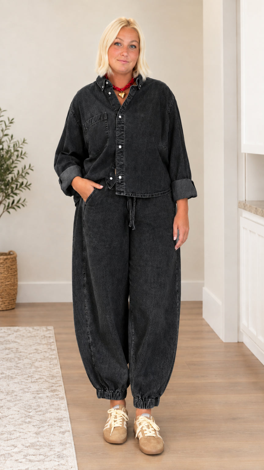 Model wearing washed black denim button-down shirt and balloon pant set