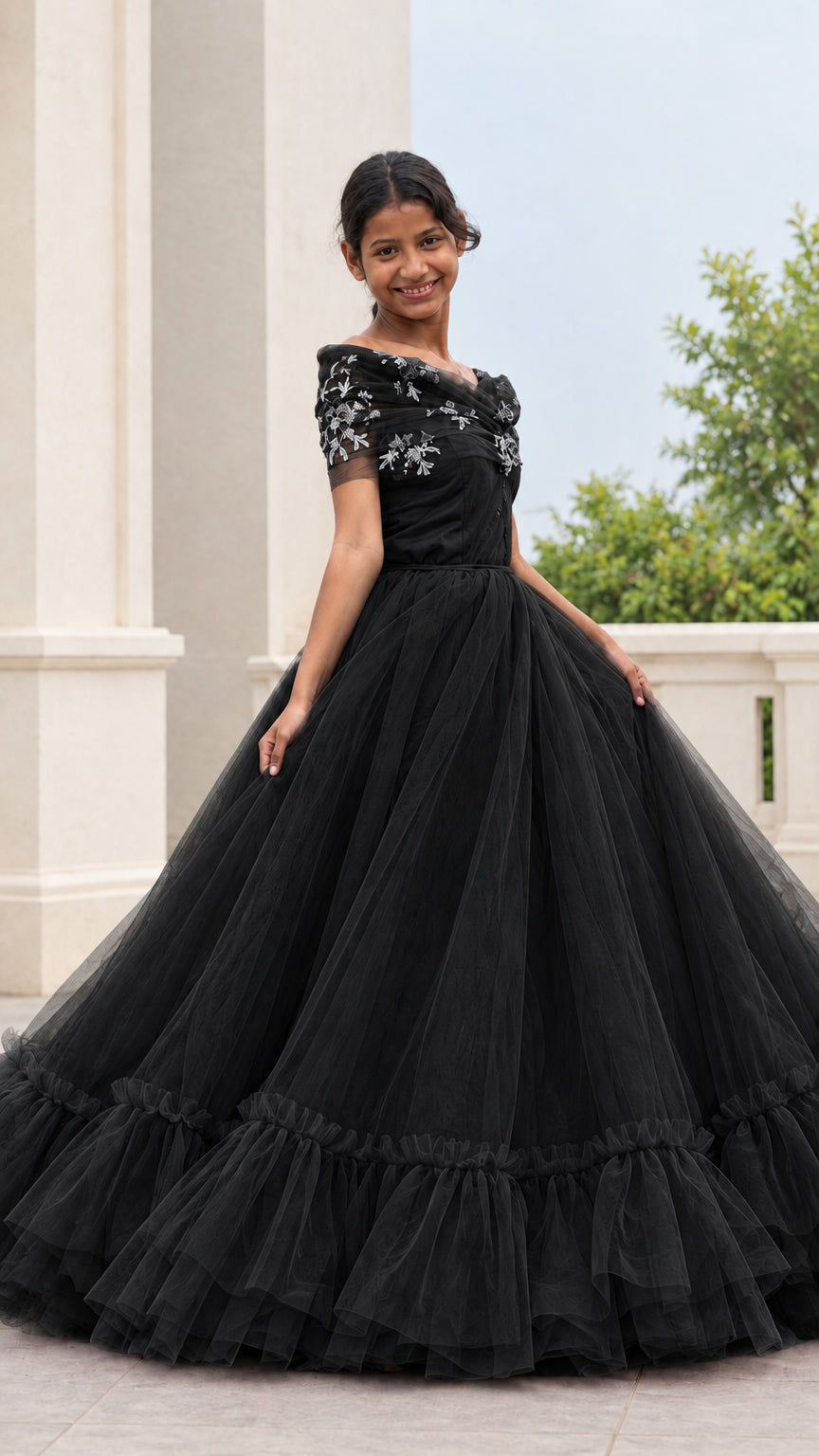 Full front view of a woman wearing a black embroidered tulle ball gown