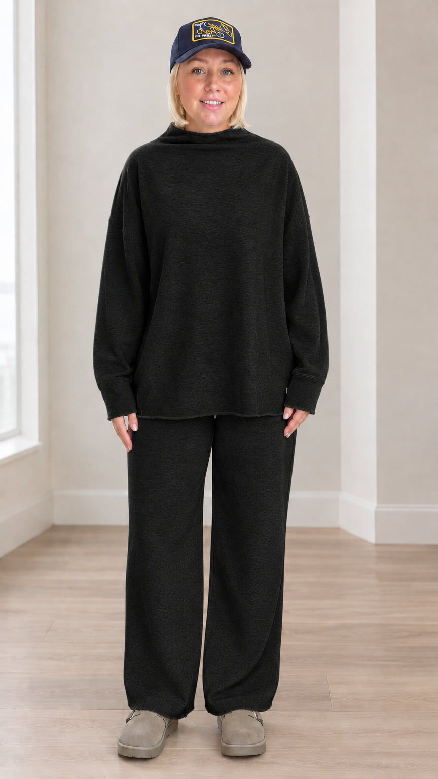 Front view of model wearing black mock neck sweatshirt and wide leg pants set