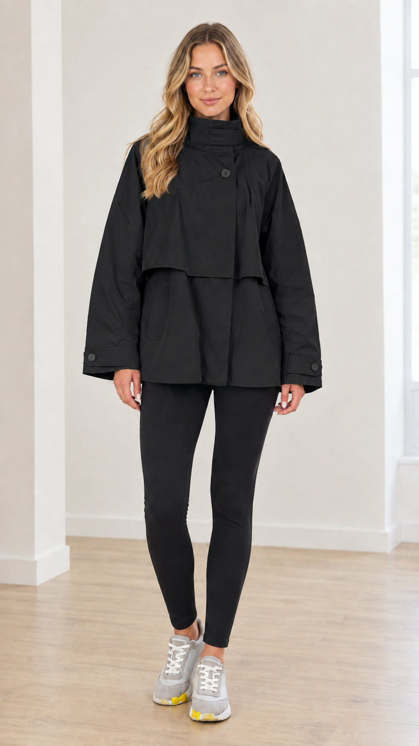 Front view of woman wearing black high neck layered short trench coat