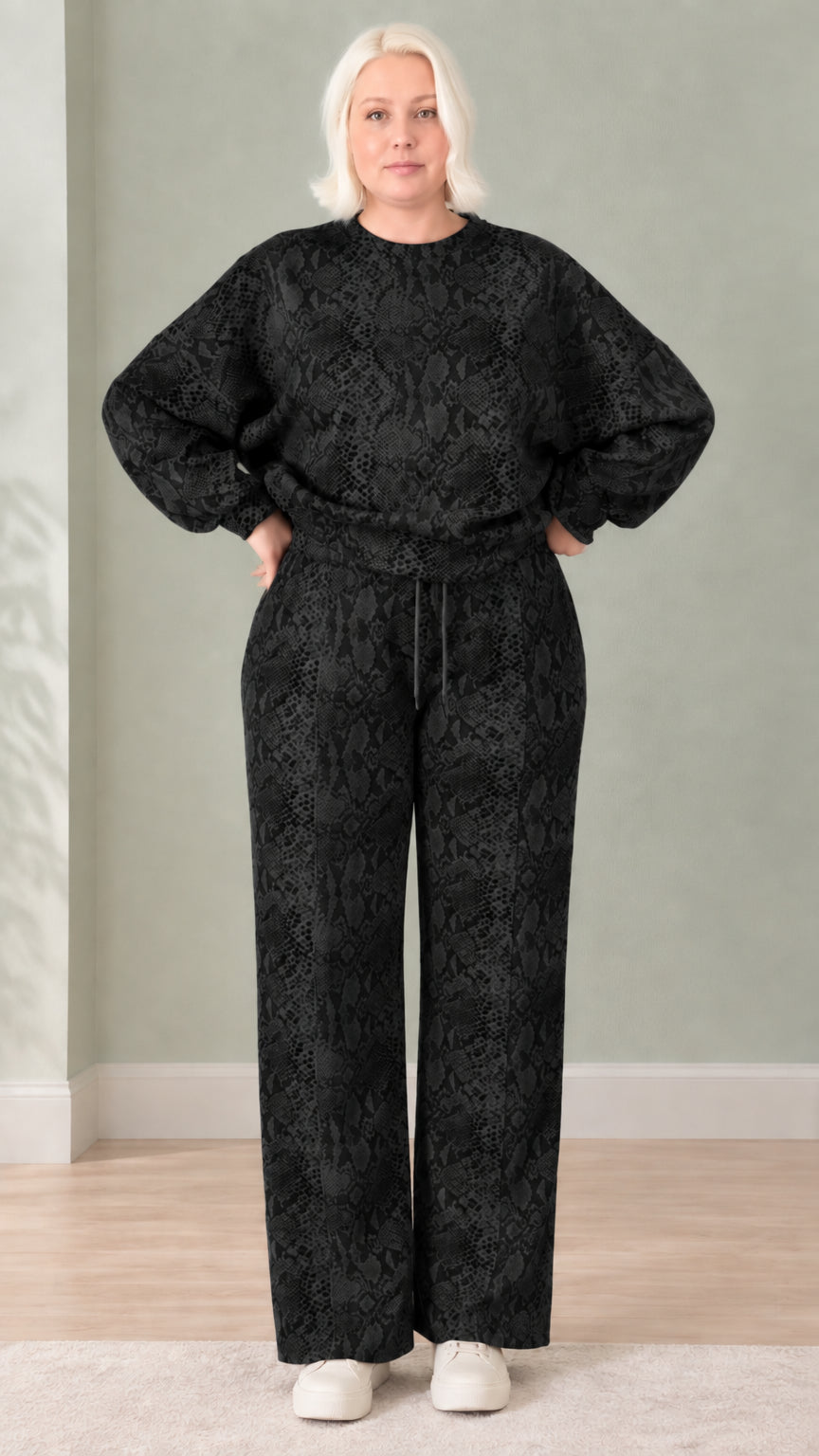 Woman wearing black snakeskin print sweatshirt and wide-leg pants set