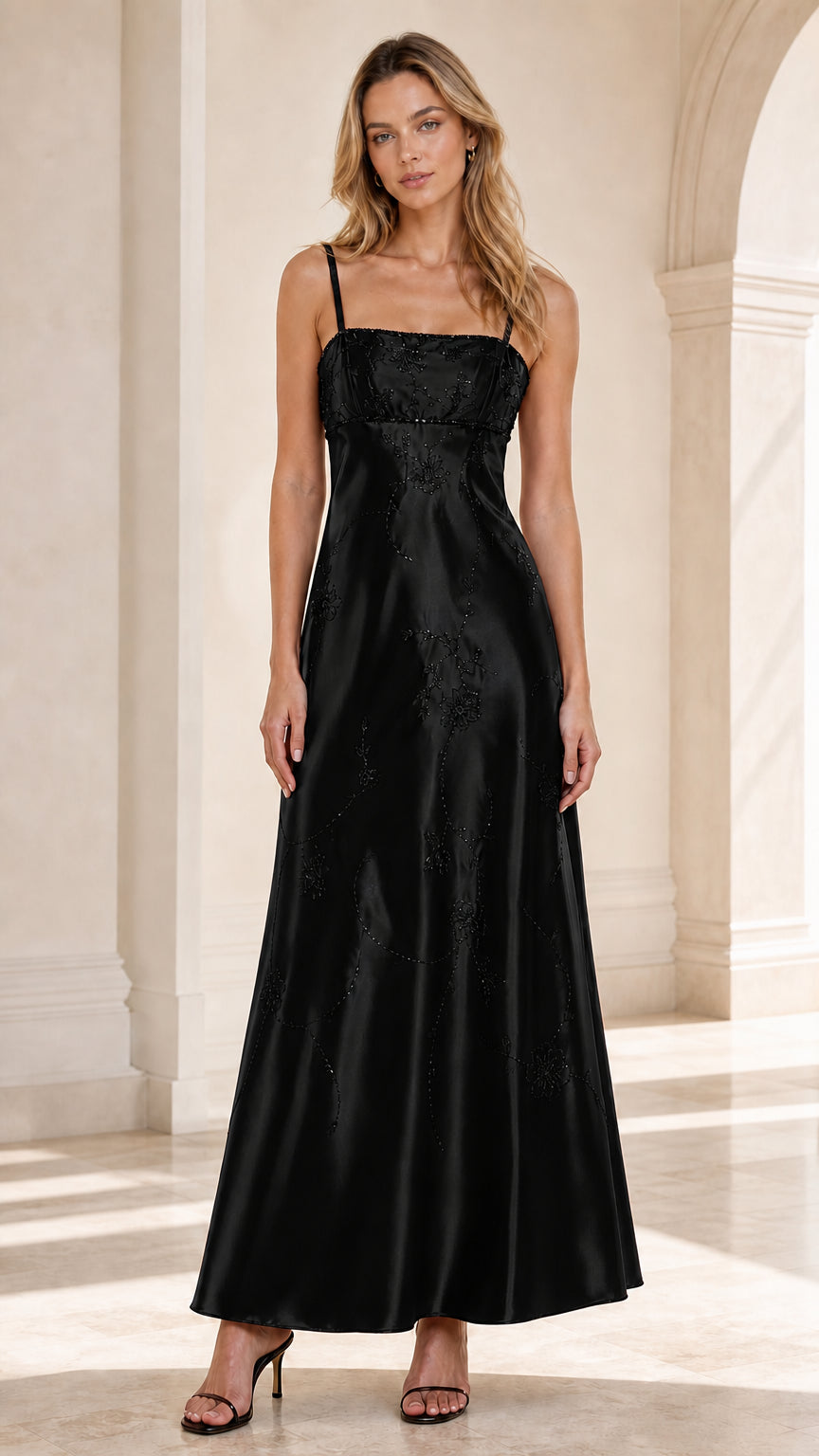 Front view of woman wearing Black embroidered satin spaghetti strap maxi dress