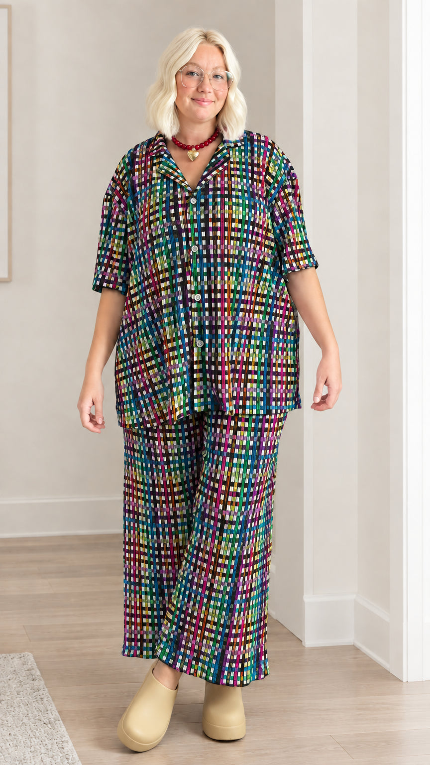 Model wearing dark multicolor plaid short sleeve shirt and matching wide-leg pants set