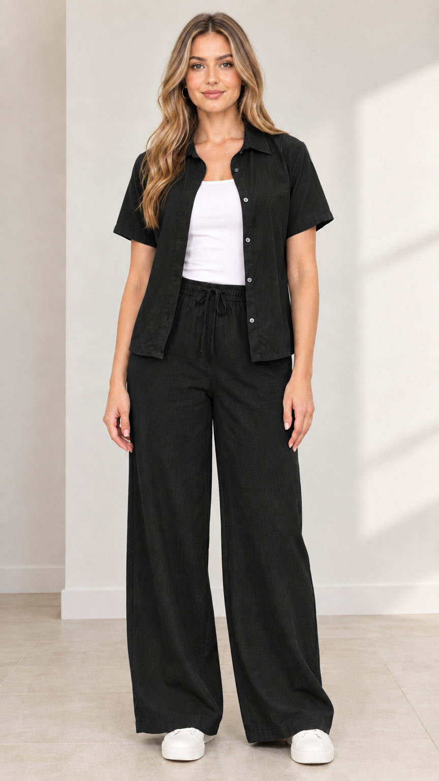 Full front view of model wearing Black short-sleeve button-down shirt and wide-leg pants set