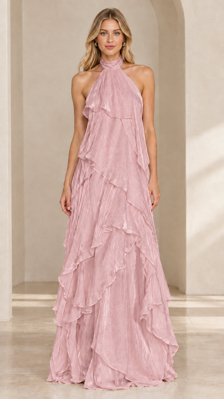 Front view of woman wearing a dusty pink tiered ruffle halter maxi gown
