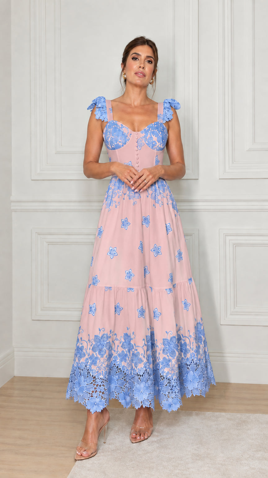 Model wearing dusty pink tiered maxi dress with contrasting blue floral embroidery