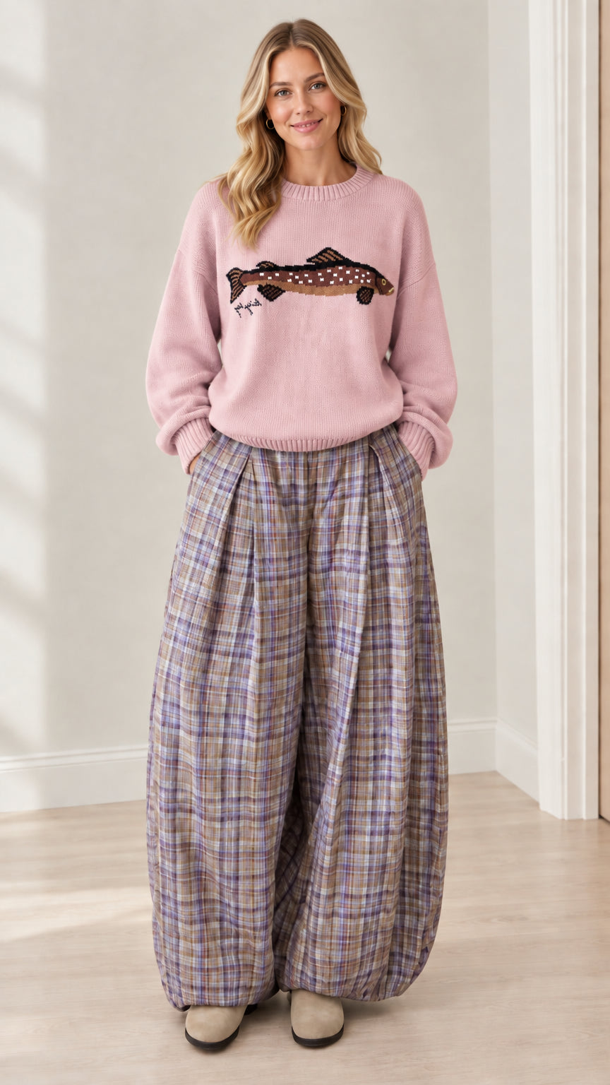 Model wearing soft pink graphic knit crewneck sweater with matching plaid balloon pants