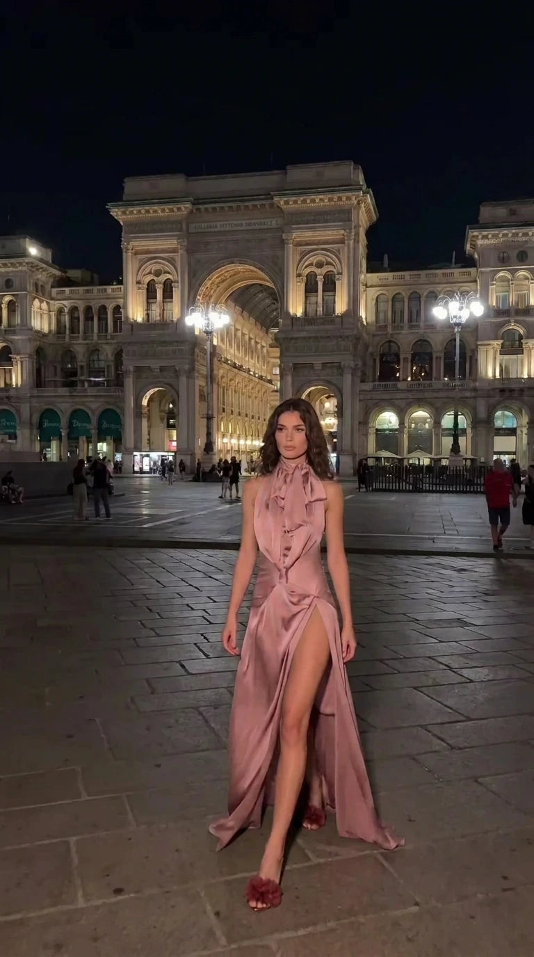 Woman modeling dusty rose satin halter neck evening dress with high leg slit
