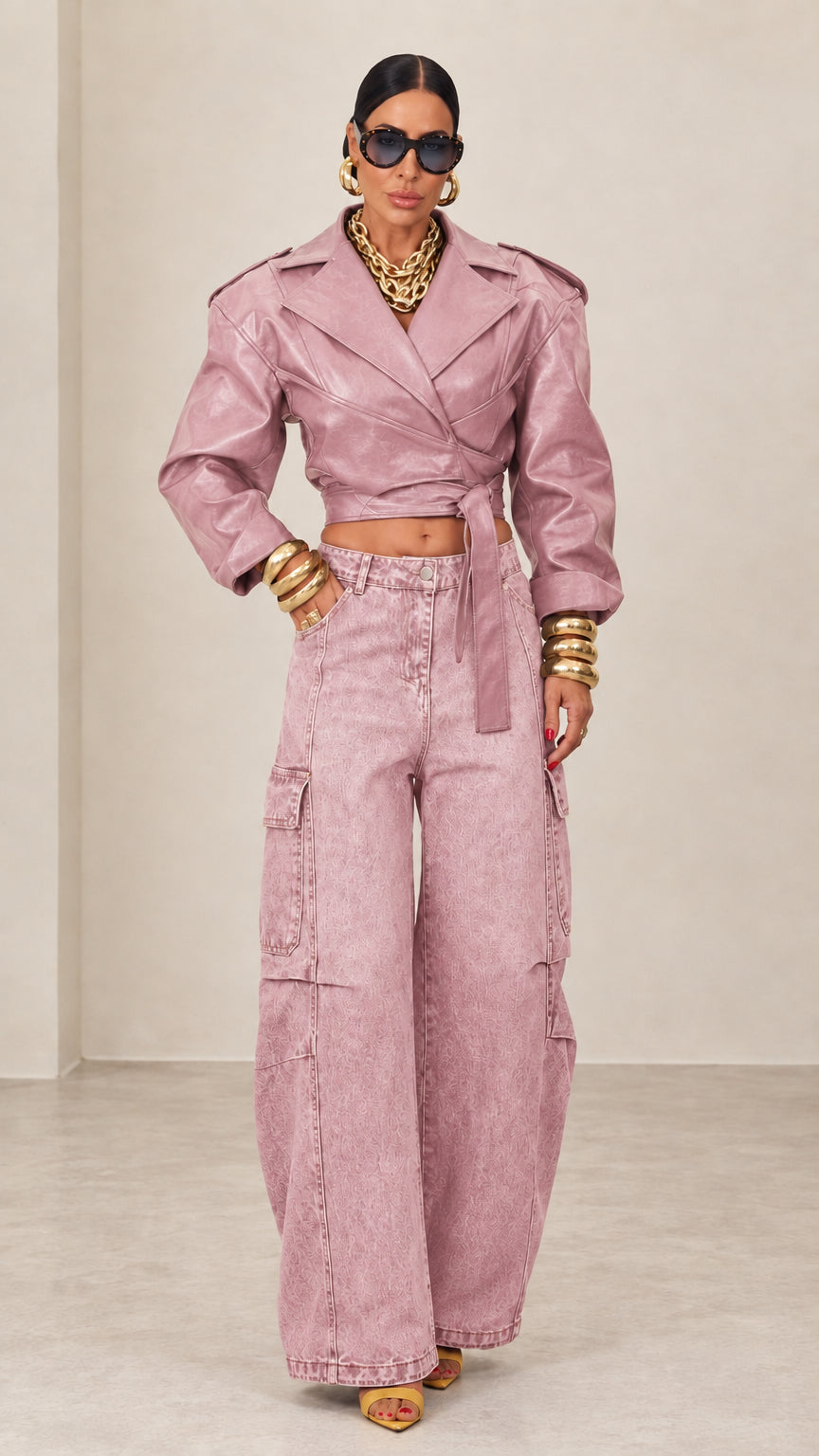 Model wearing dusty pink cropped faux leather wrap jacket with matching wide-leg trousers
