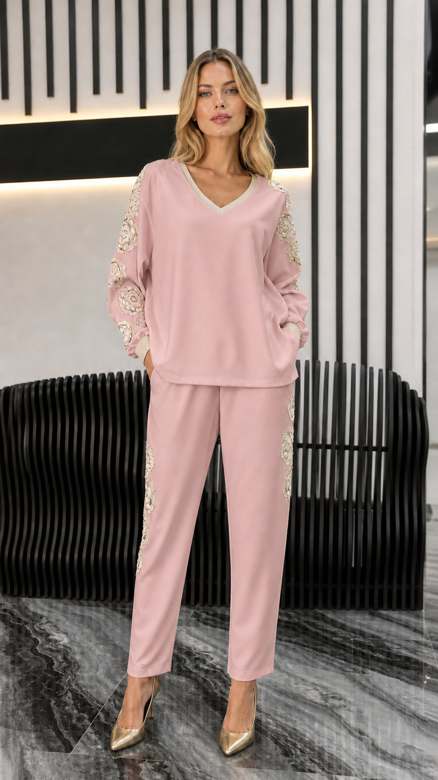 Front view of woman wearing blush pink embroidered two-piece set with gold pumps