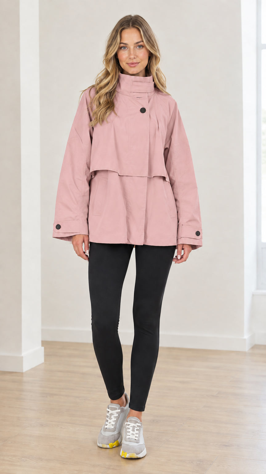Front view of woman wearing dusty pink high neck layered short trench coat