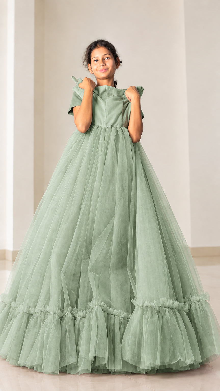 Front view of model in sage green tiered ruffle hem tulle ball gown