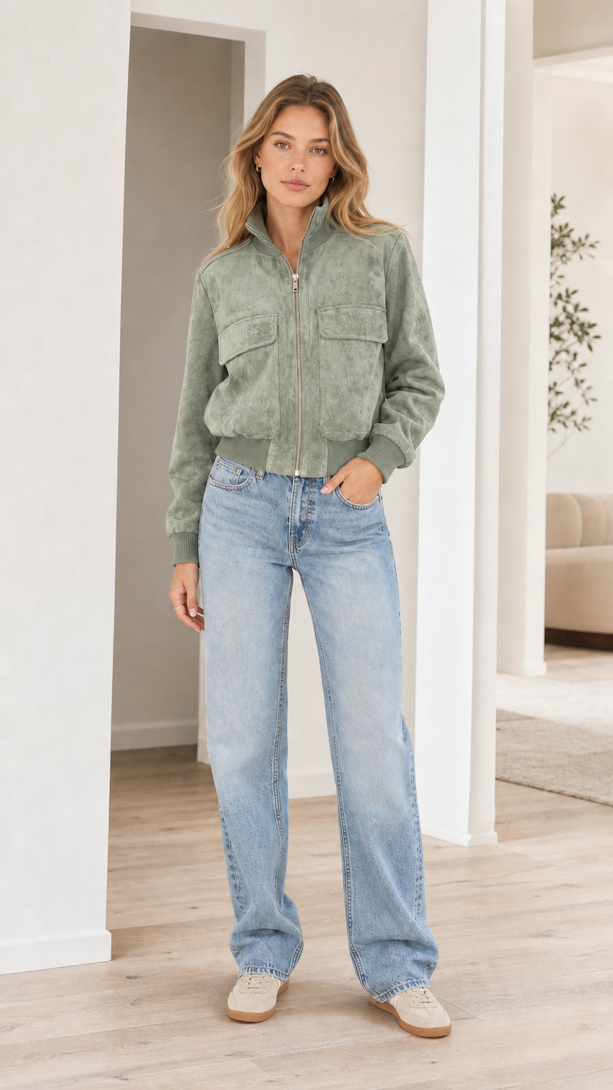 Model wearing sage green faux suede zip-up bomber jacket with jeans