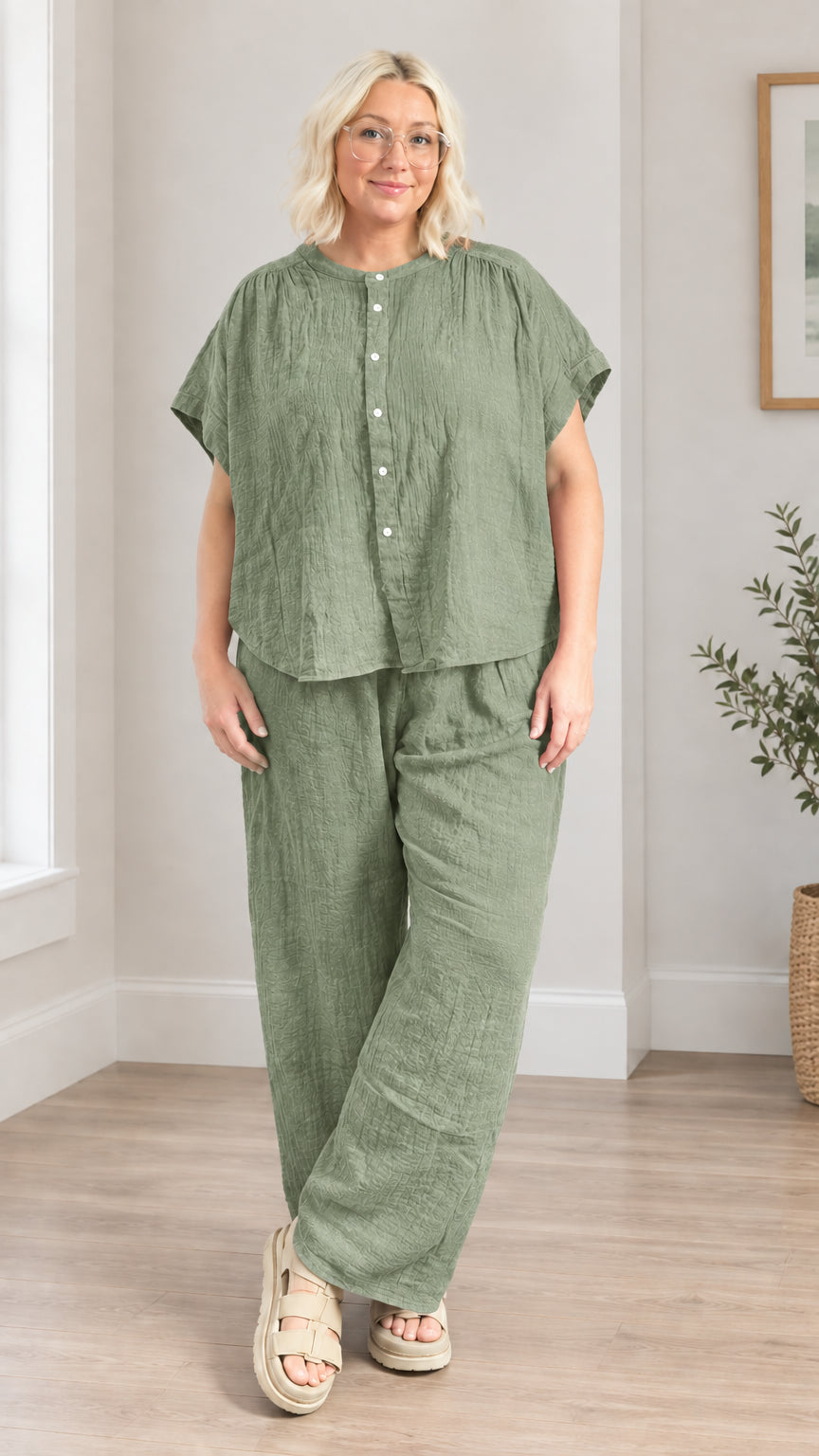 Model wearing sage green button-front top and coordinating wide leg pants set