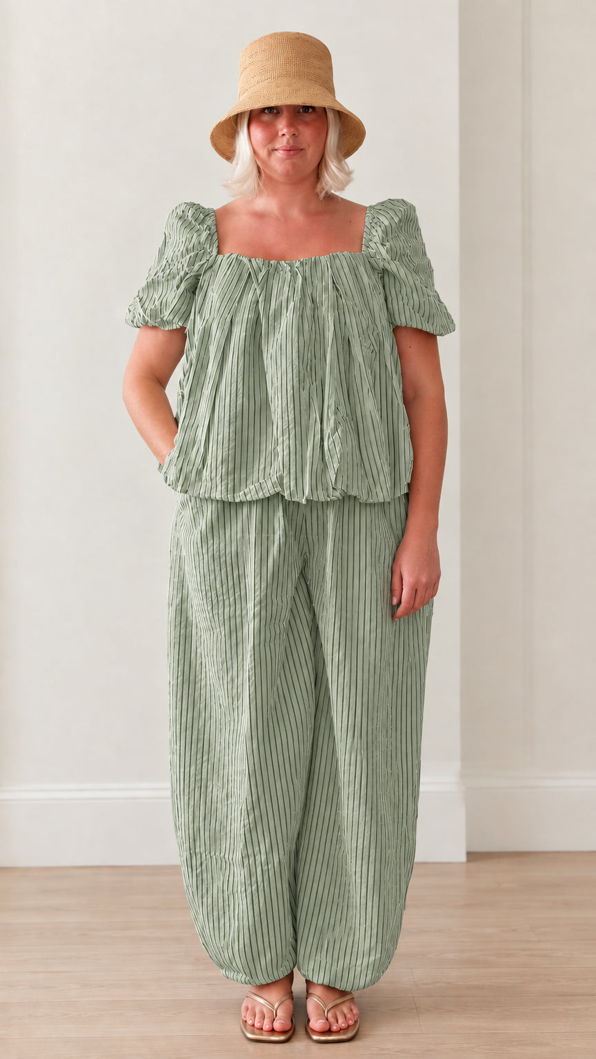 Woman wearing sage green striped square neck puff sleeve top and matching lantern pants set