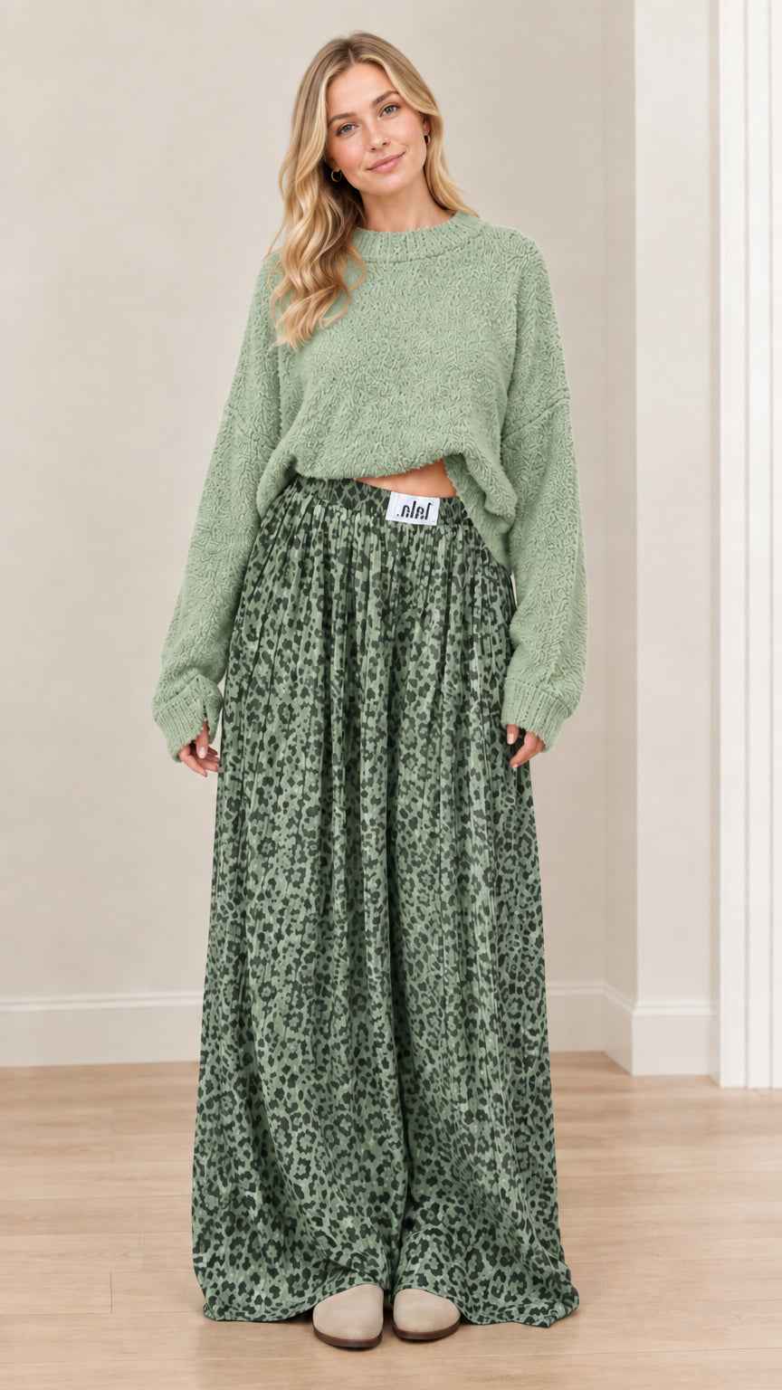 Model wearing sage green knit sweater and matching sage green animal print wide-leg pants