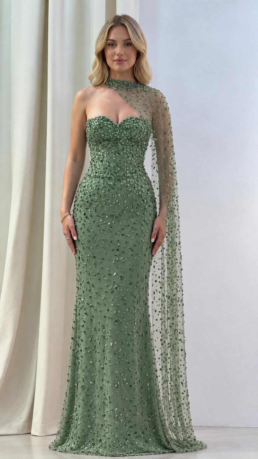 Model wearing sage green beaded asymmetric cape evening dress