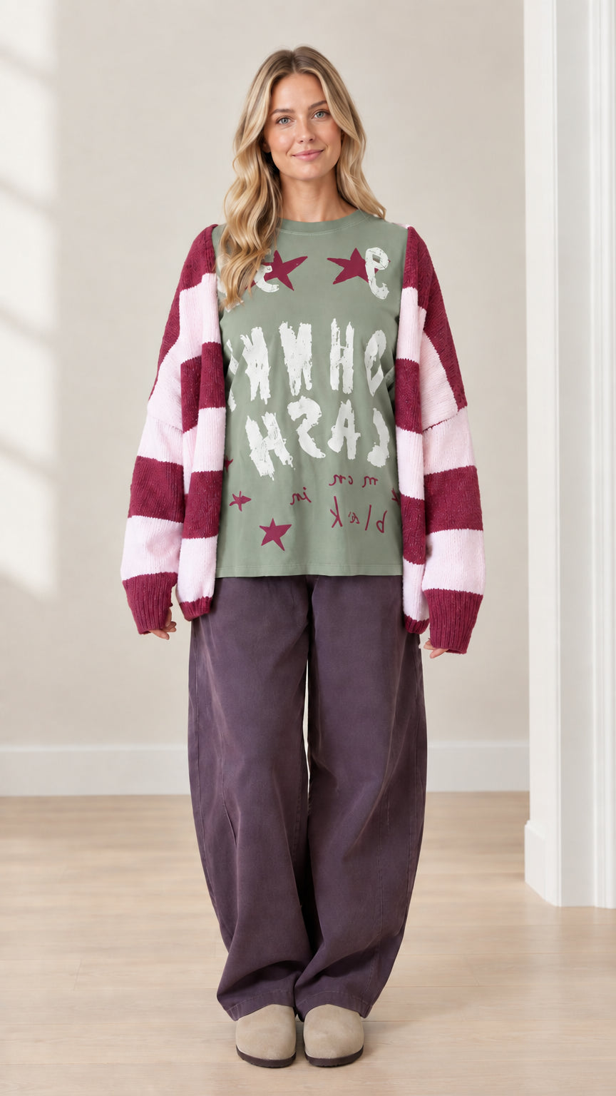 Full front view of model wearing sage green graphic top with striped cardigan and wide leg pants
