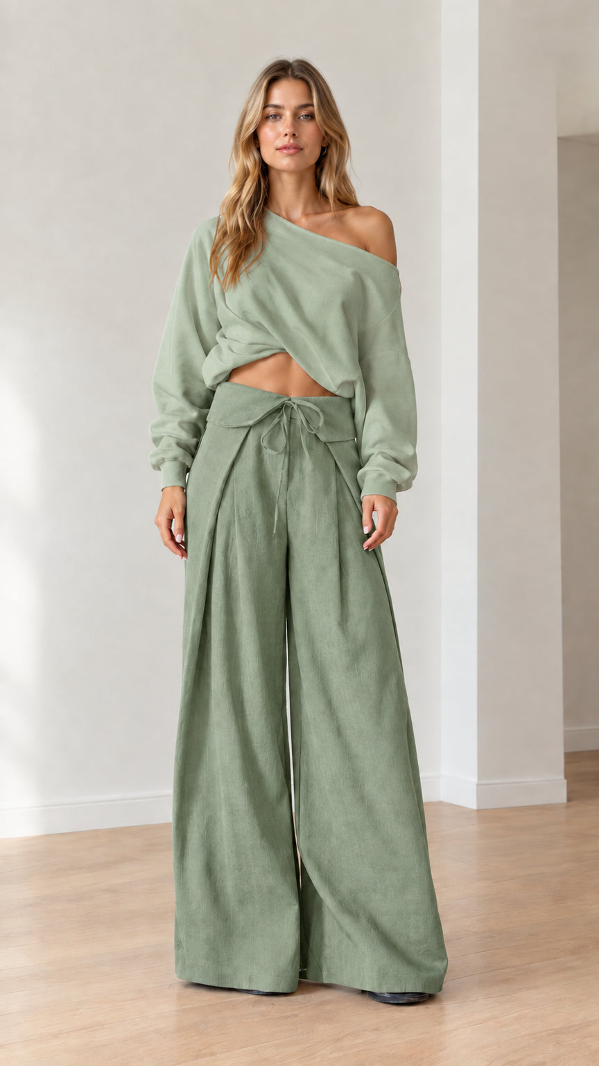 Model wearing matching sage green off-the-shoulder top and wide-leg trousers set