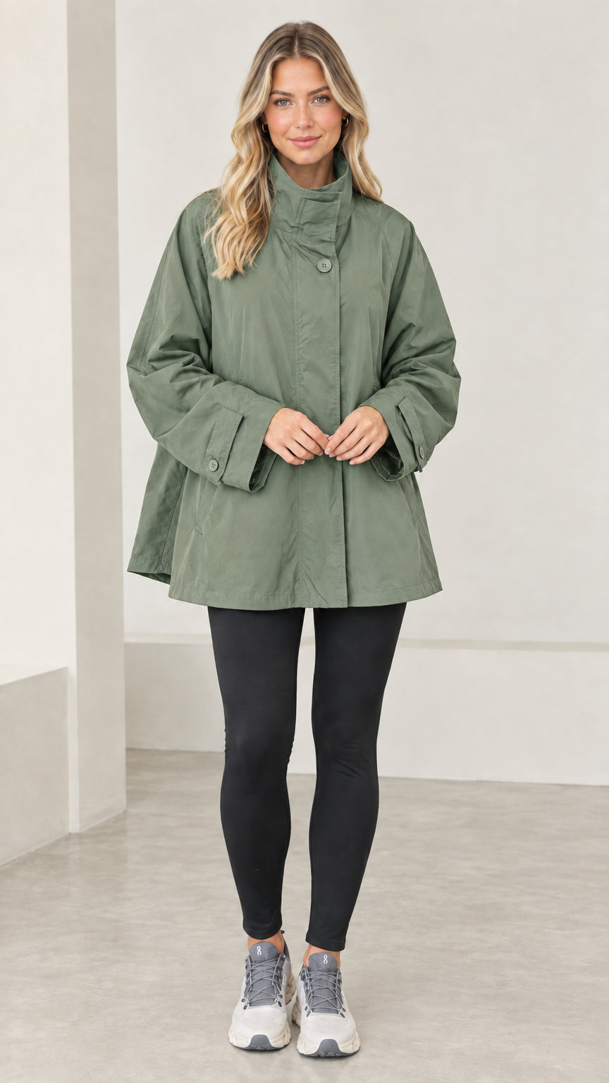 Front view of model wearing sage green A-line swing trench jacket