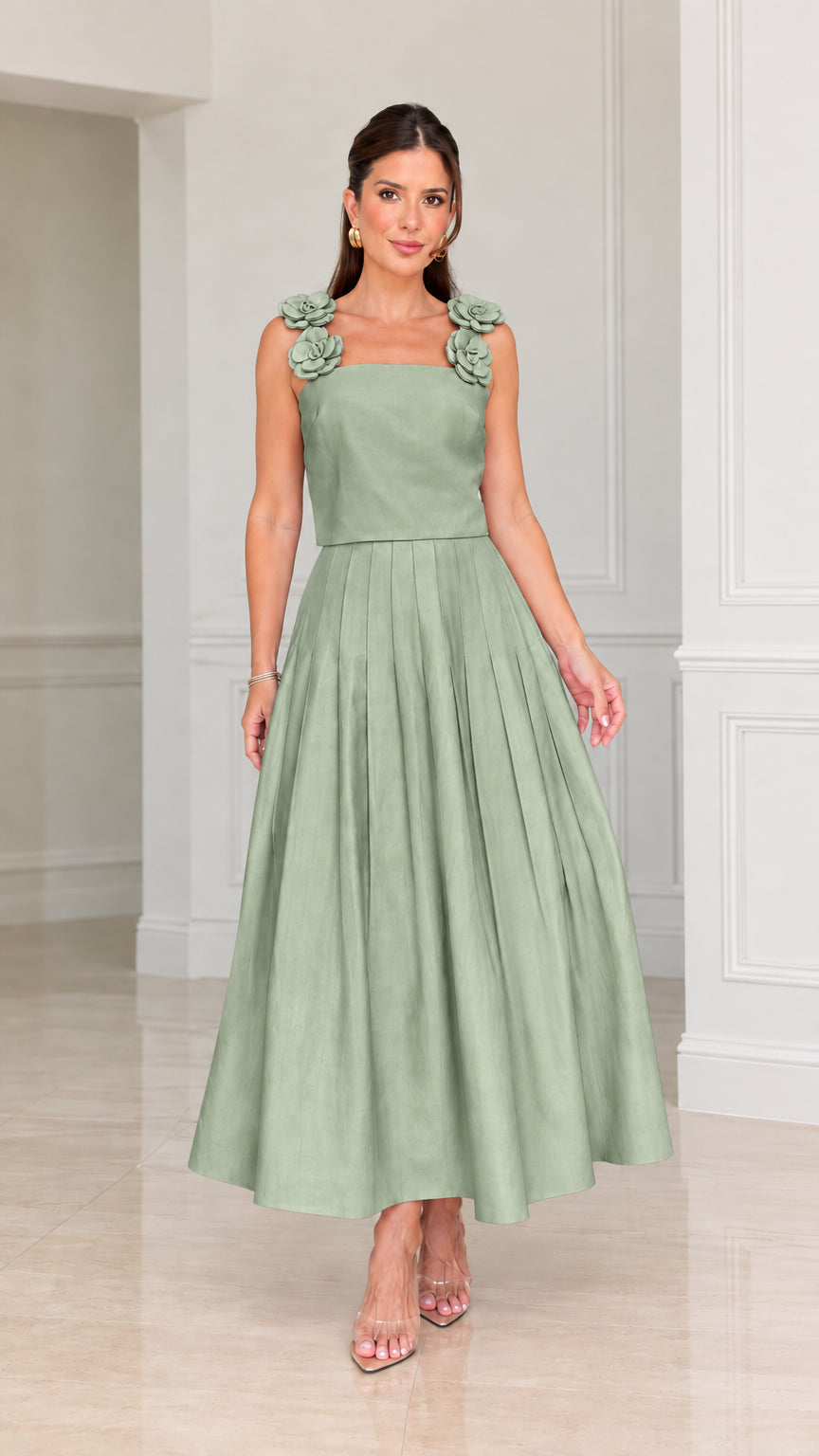 Front view of woman wearing sage green floral strap pleated midi cocktail dress