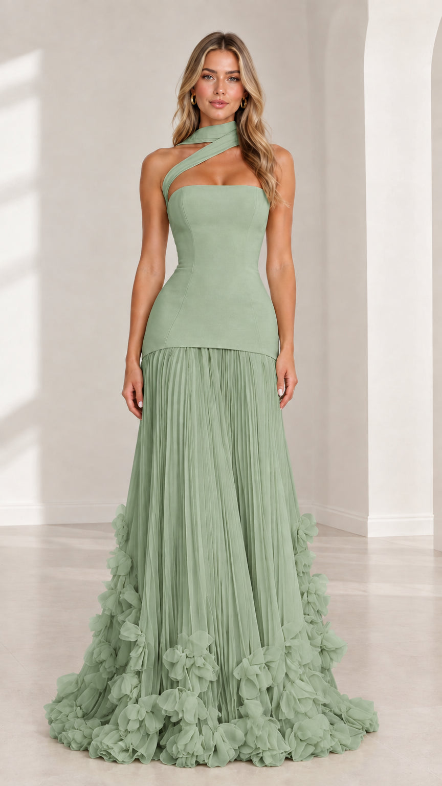 Front full-length view of model wearing sage green asymmetric drop waist evening gown