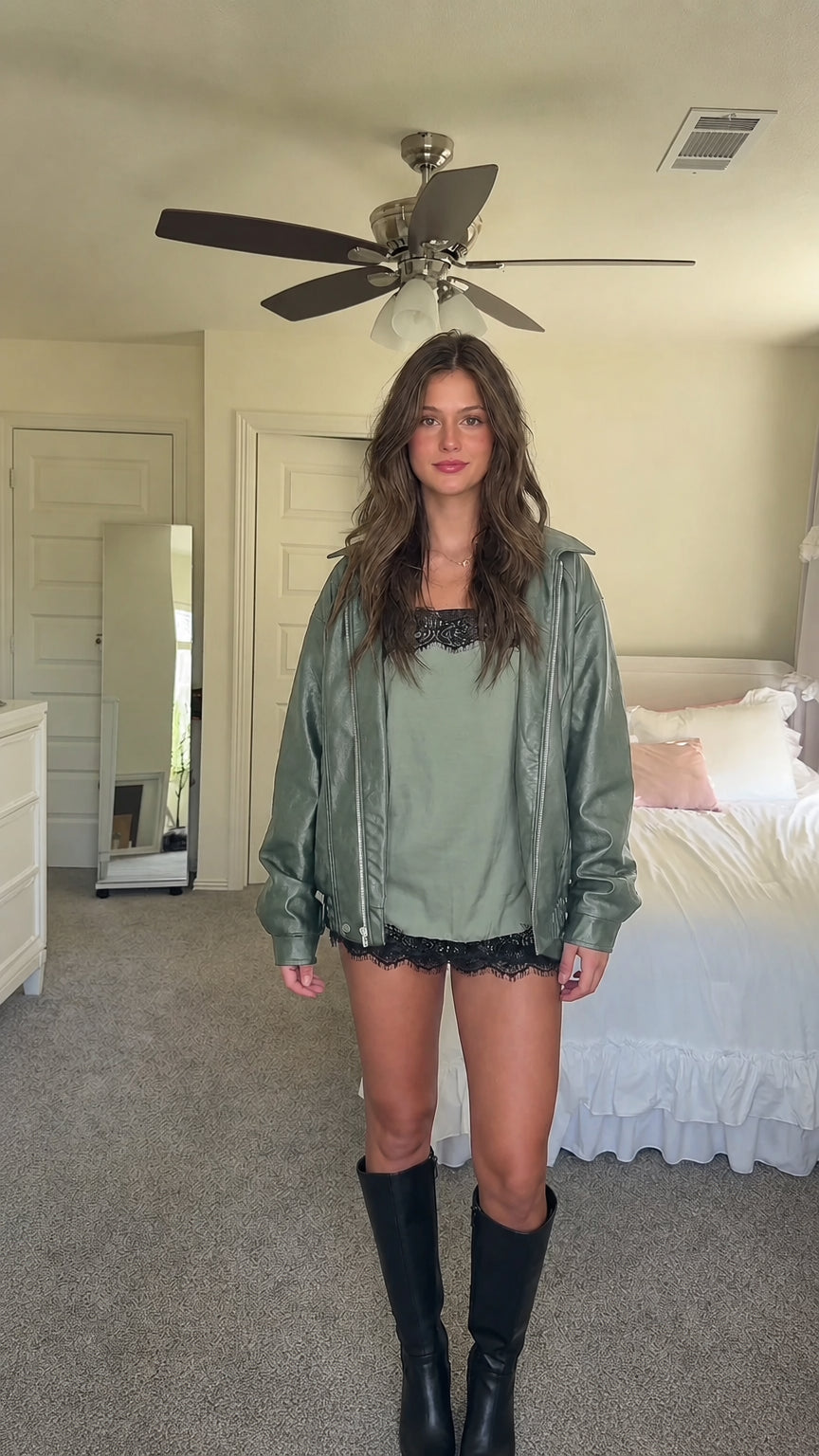 Sage green oversized faux leather bomber jacket layered over matching cami top