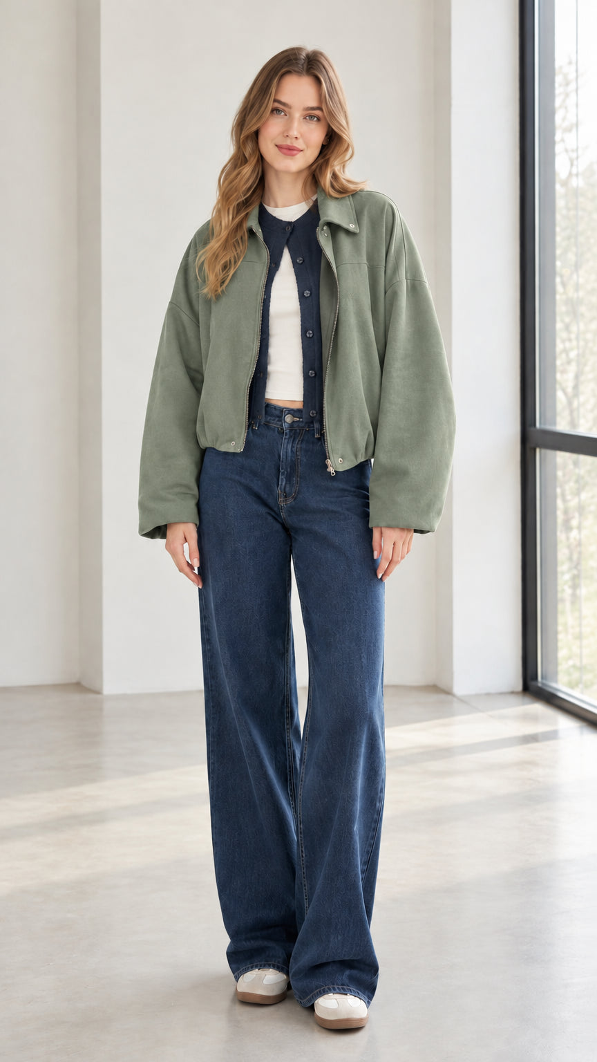 Woman wearing sage green collared zip-up jacket with denim pants